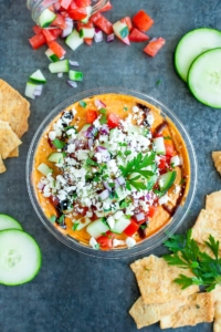 Take store bought bean dip from hummus to YUMMUS with this deliciously speedy shortcut. Tasty hummus is piled high with a mountain of toppings including feta, cucumber, onion, parsley, and drizzled with a sweet and savory balsamic glaze.