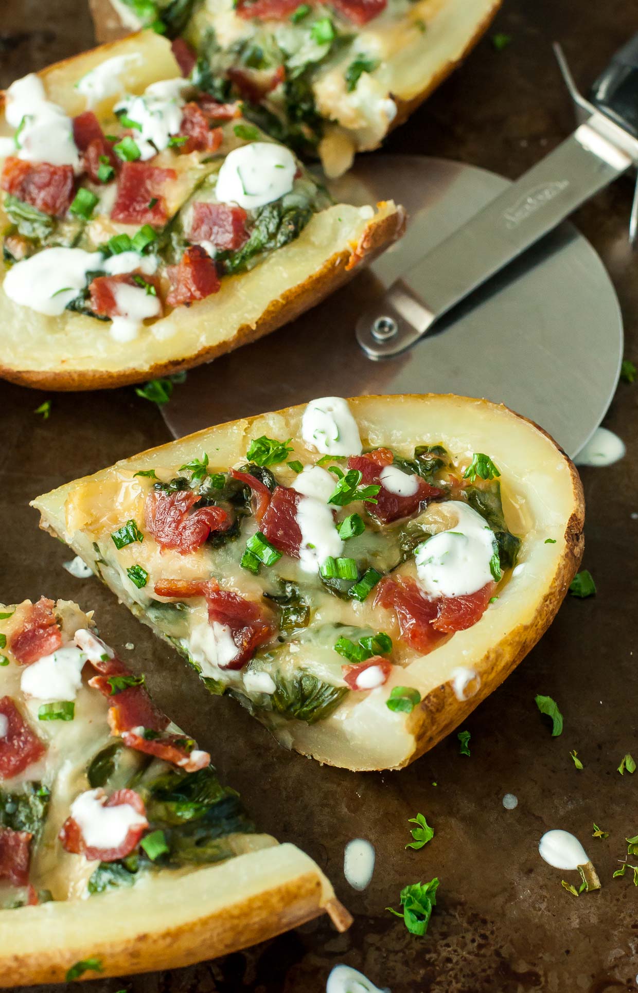 Creamy spinach artichoke dip and crispy loaded baked potato skins join forces, resulting in the ultimate party appetizer! We LOVE these spinach and artichoke loaded potato skins!