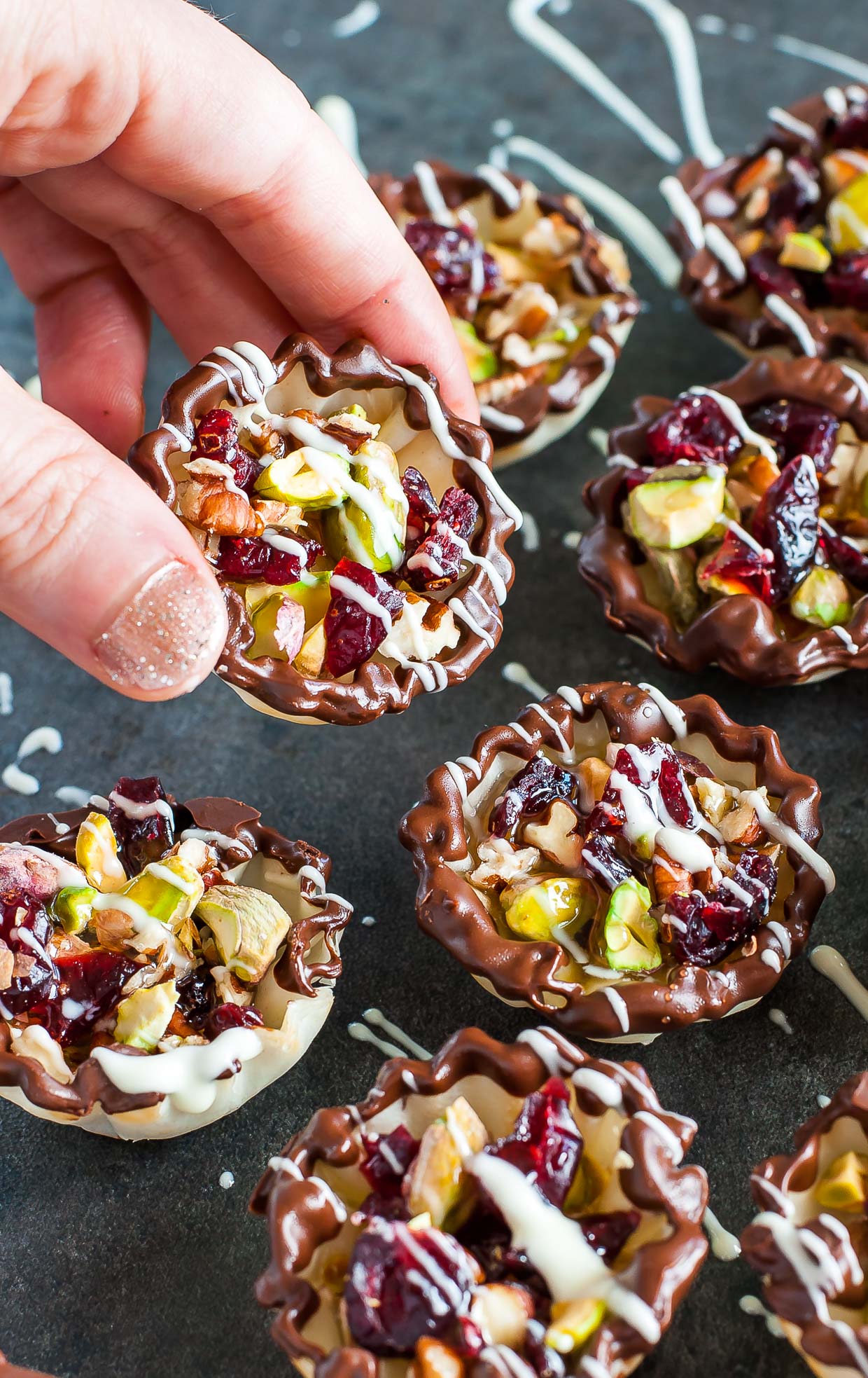 Dipped and drizzled in chocolate, these Cranberry Bliss Baklava Bites are easy to make and even easier to devour! This pint-sized no-bake phyllo cups are perfect for the holidays!