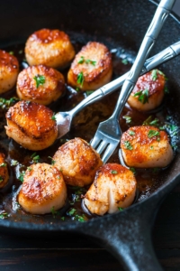 These quick and easy Sriracha Glazed Seared Scallops are finished off with a spicy + super flavorful homemade Sriracha pan sauce! Delicious!