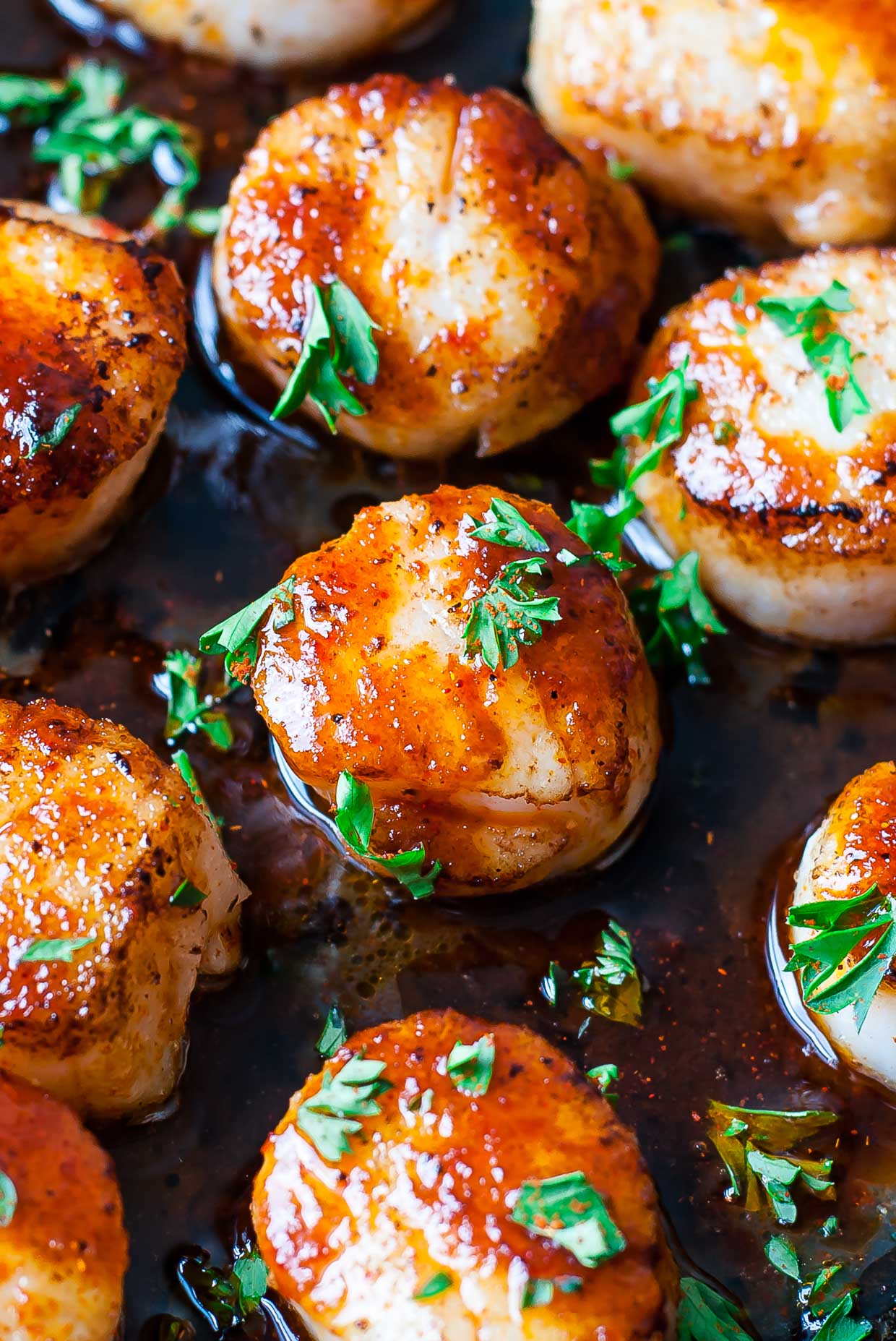 These quick and easy Sriracha Glazed Seared Scallops are finished off with a spicy + super flavorful homemade Sriracha pan sauce! Delicious!