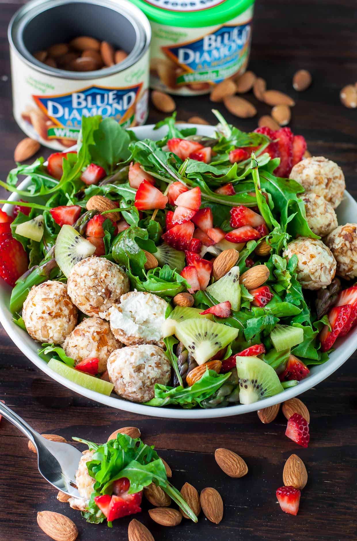 Just say no to boring salads! This sweet and savory Almond Crusted Goat Cheese Salad is flecked with strawberries and kiwi and topped with a fruity balsamic dressing.