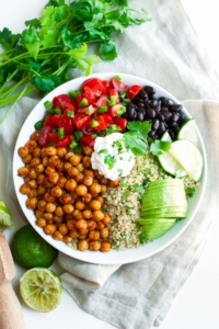 roasted chickpea quinoa taco salad in white bowl with lime wedges