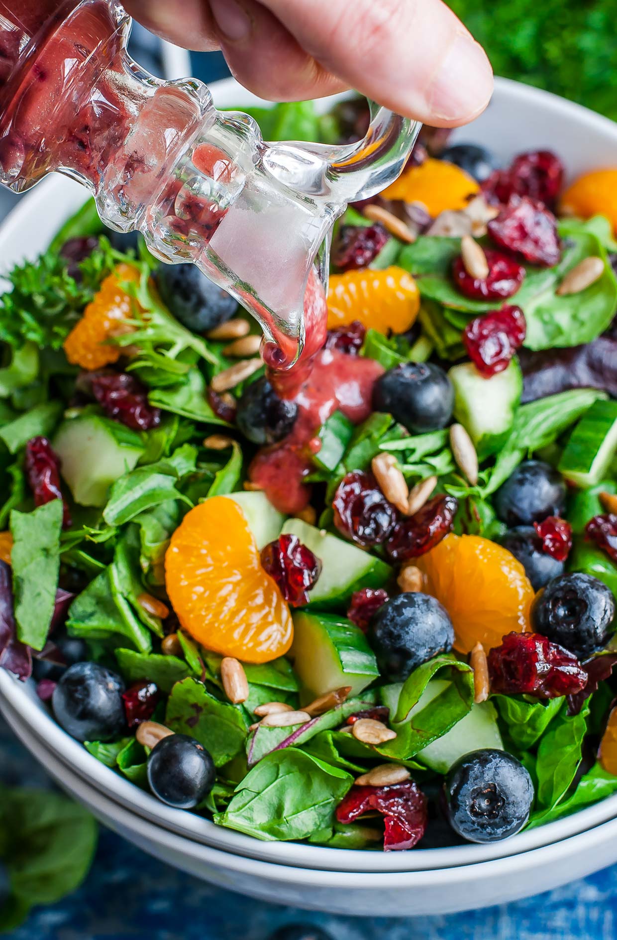Pouring Balsamic Blueberry Salad Dressing on Salad