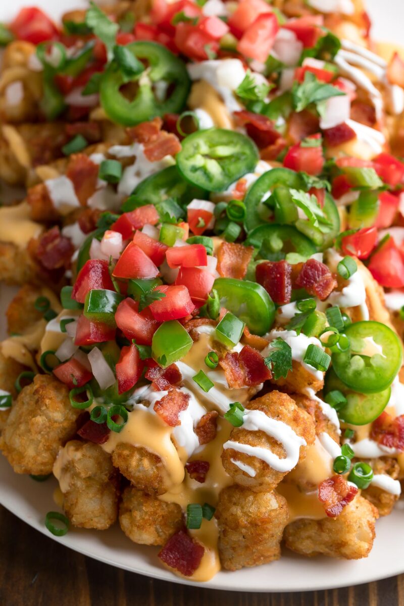 Loaded Tater Tot Nachos topped with Cheese, Sour Cream, Pico de Gallo, Jalapeños, Bacon and More
