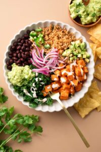 Vegetarian Power Bowls with roasted sweet potato, quinoa, black beans, kale, red onion, and avocado