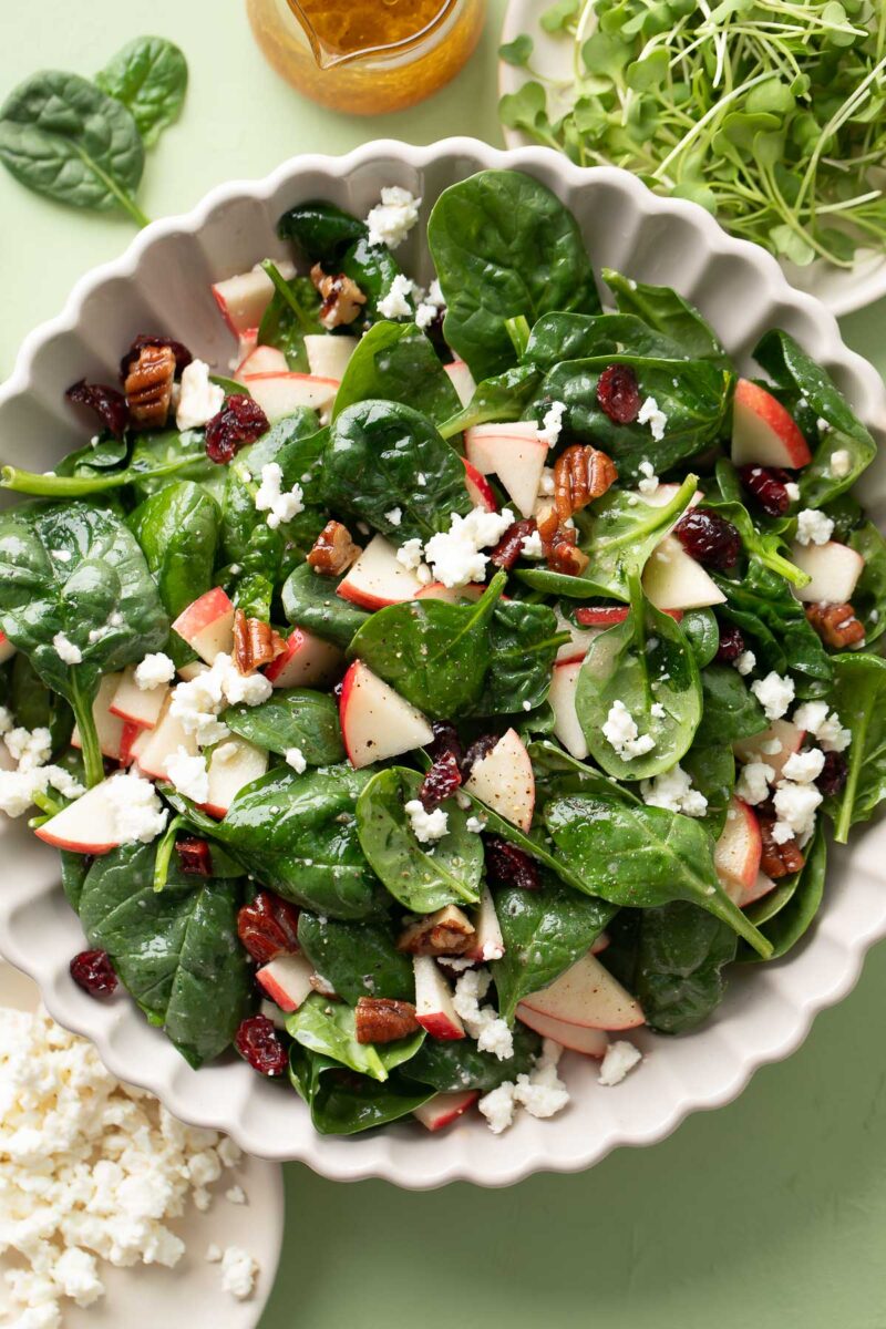 spinach salad bowl with apples, candied pecans, feta, and homemade maple citrus dressing