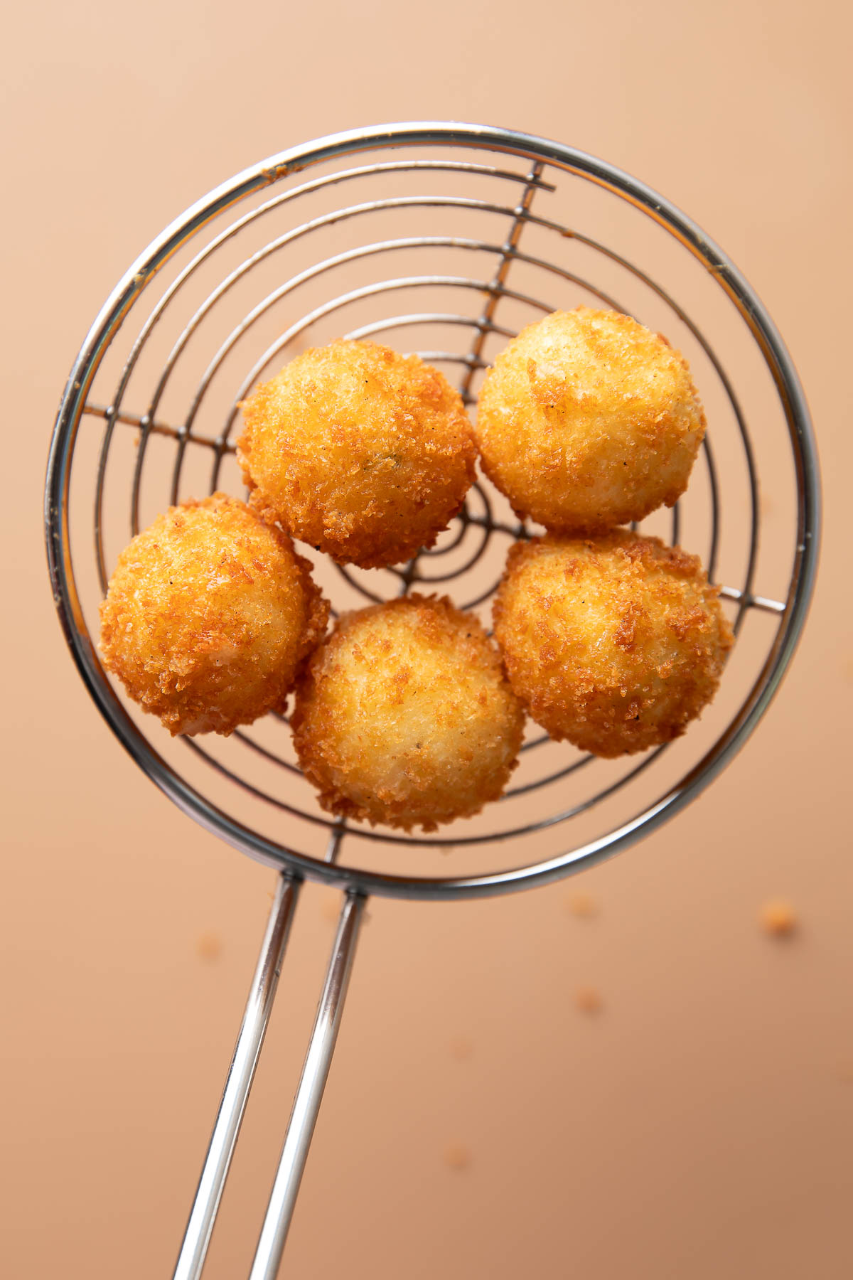 remove fried mashed potato balls from oil using a slotted spoon
