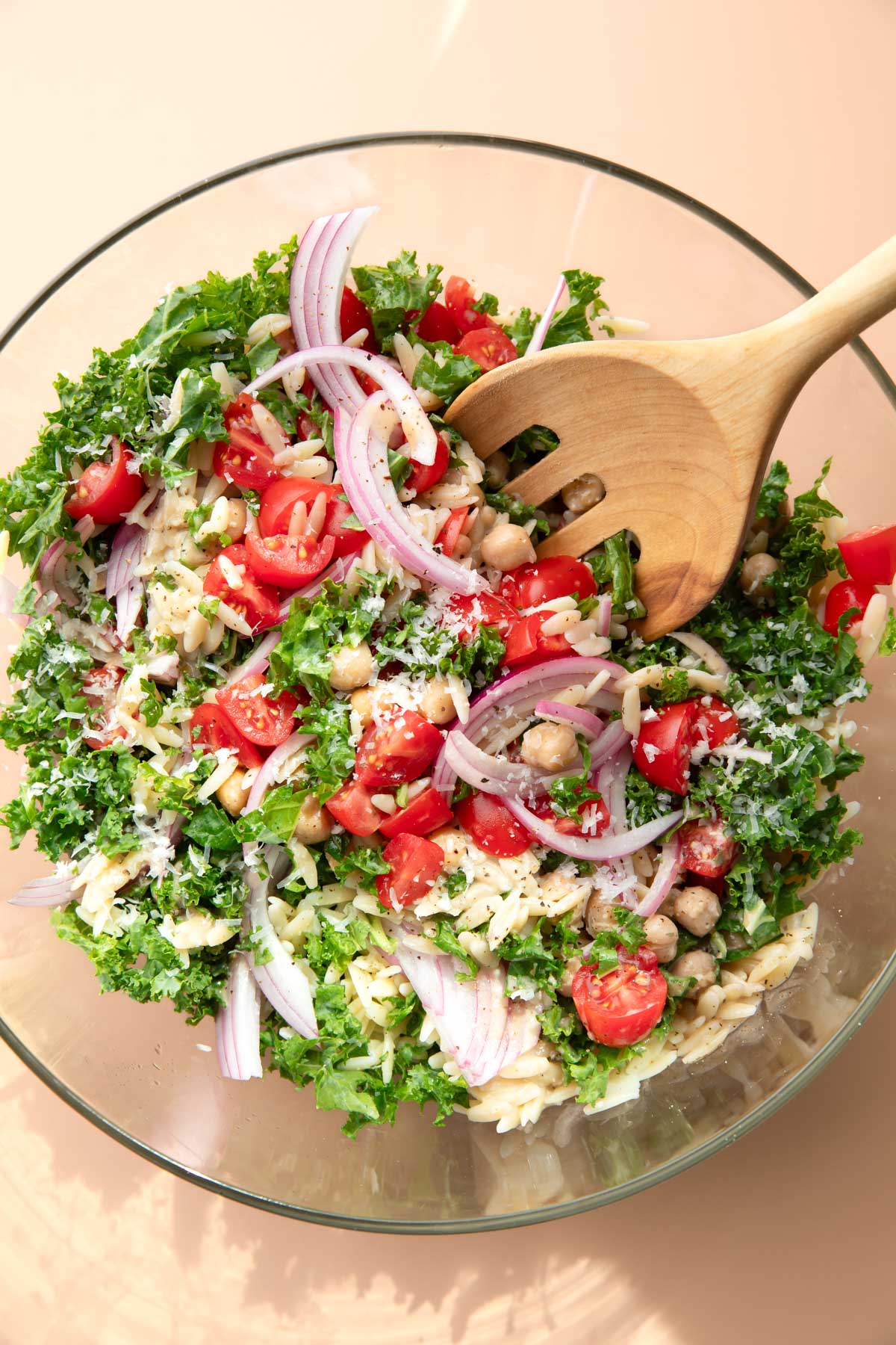 Kale Pasta Salad with orzo, red onions, tomatoes, chickpeas, and parmesan cheese