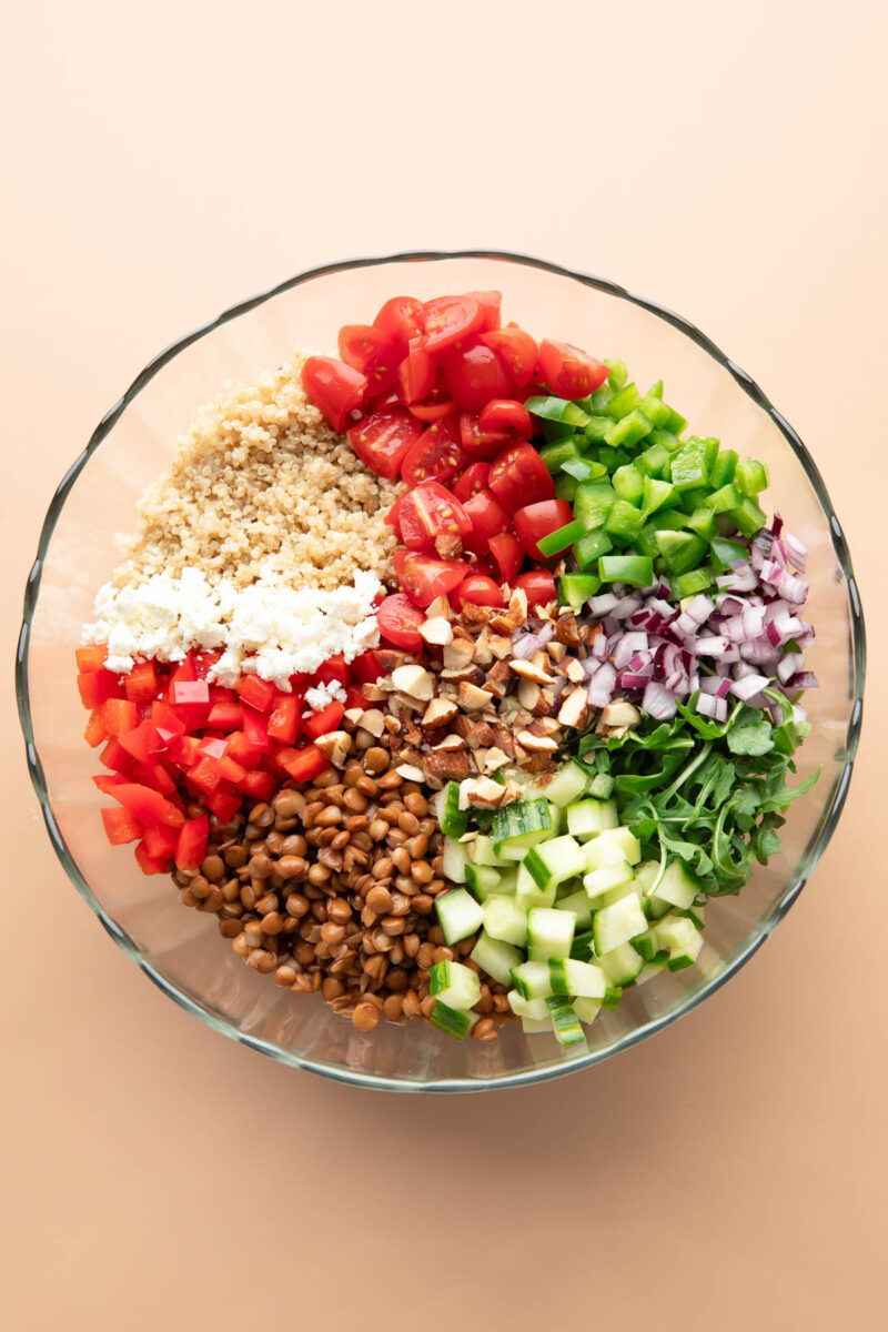 Mediterranean Lentil Salad ingredients in a glass serving bowl