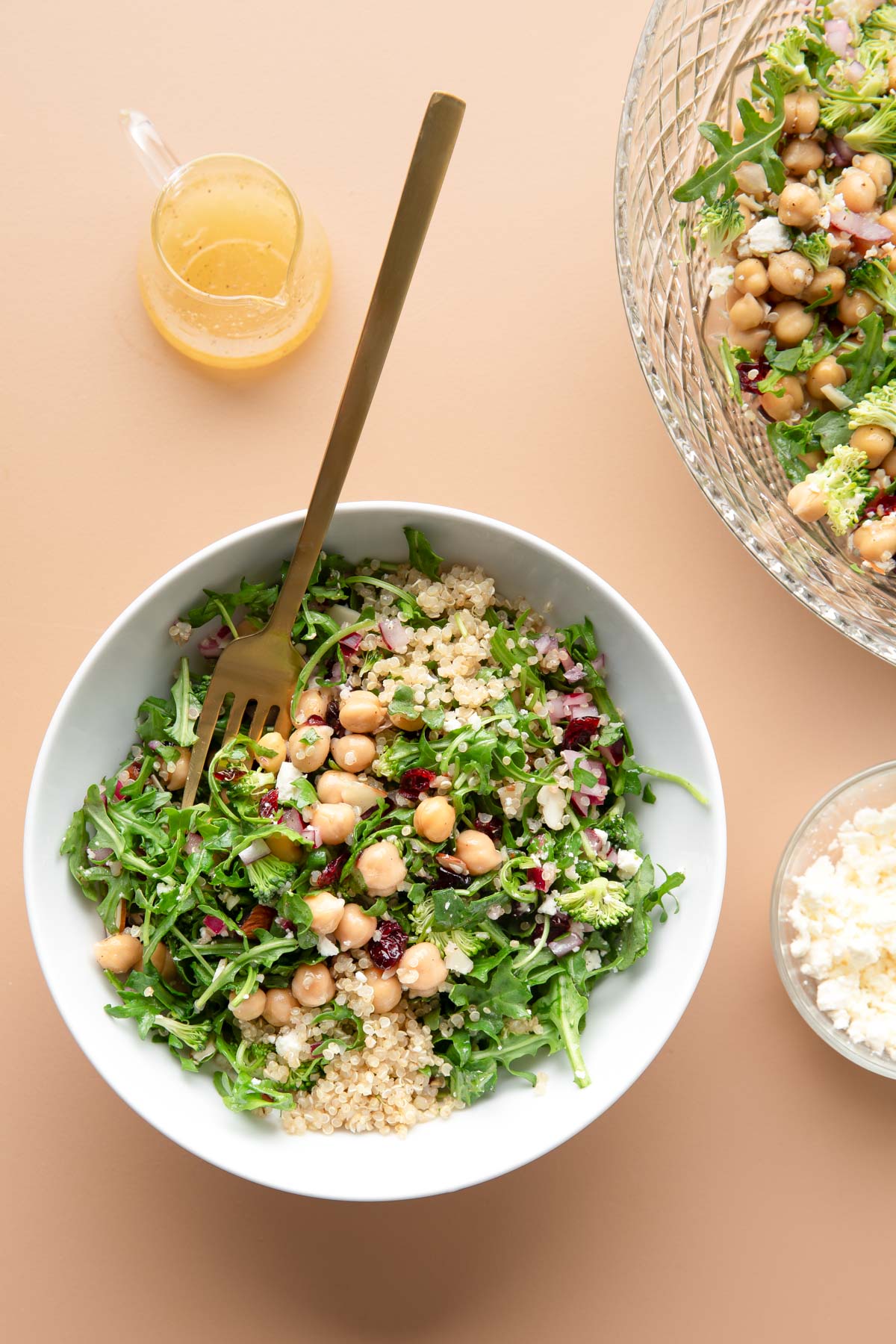bowl of quinoa arugula salad with a side of crumbled feta and lemon dressing